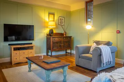 a living room with a tv and a chair and a coffee table at Marina View, Near Canal and Mountains in Brecon