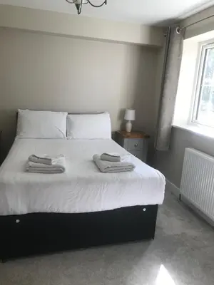 a bedroom with a bed with two towels on it at Haul y Bore in Aberystwyth