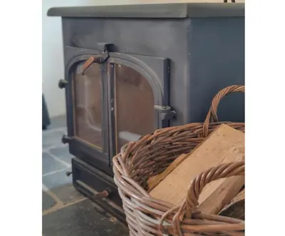 a wicker basket sitting next to a stove at Gaer Hall Guilsfield a country mansion with hottub in Welshpool
