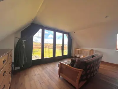 a living room with a couch and a large window at Hideaway in the Brecon Beacons in Brecon
