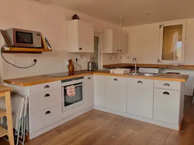 a kitchen with white cabinets and a microwave at Hideaway in the Brecon Beacons in Brecon