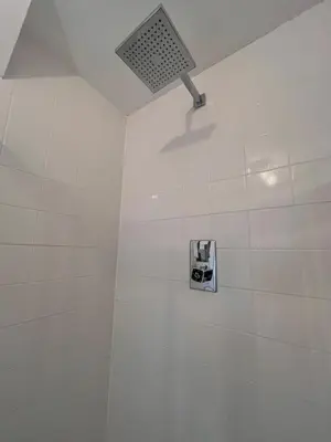 a white tiled shower with a camera on the wall at Hideaway in the Brecon Beacons in Brecon
