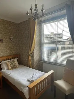 a bedroom with a bed and a window and a chair at Tal Y Don Hotel in Barmouth