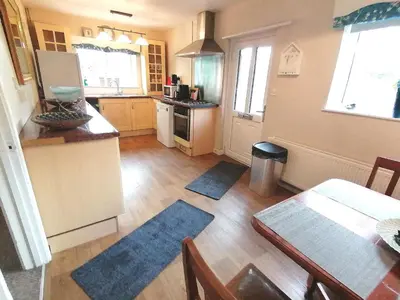 a kitchen with a table and a dining room at Cartref Bach in Llanybydder