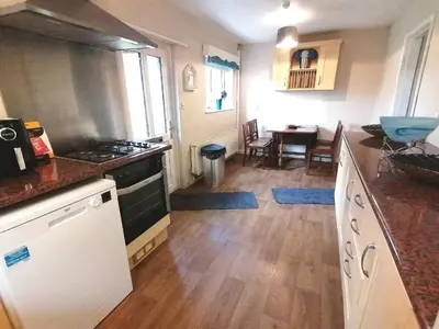 a kitchen with a stove and a counter top at Cartref Bach in Llanybydder