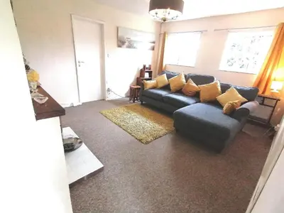 a living room with a blue couch and yellow pillows at Cartref Bach in Llanybydder