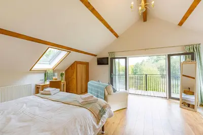 a bedroom with a bed and a balcony at Rhosllyn Retreats - Lakeside Lodge in Rhayader