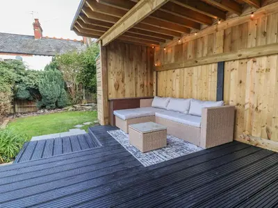 a wooden patio with a couch on a deck at 18 Church Street in Llangollen