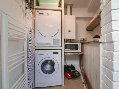 a laundry room with a washing machine and a microwave at 18 Church Street in Llangollen