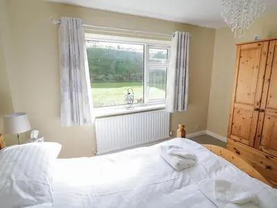 a bedroom with a white bed and a window at The Highlands in Church Stretton