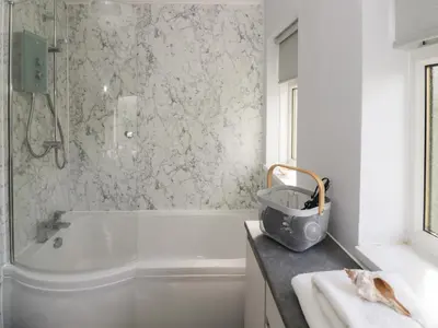 a white bathroom with a tub and a sink at The Highlands in Church Stretton