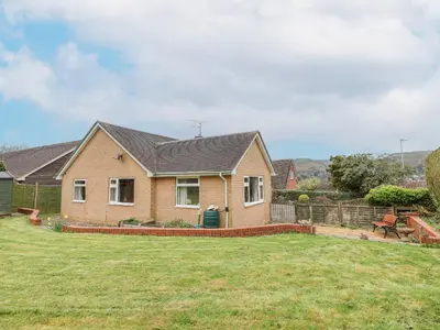 a house with a grass yard in front of it at The Highlands in Church Stretton