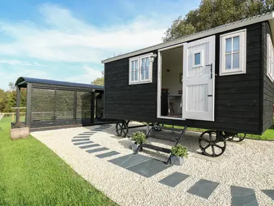 a black and white tiny house on a gravel patio at Dragonfly Shepherd's Hut in Aberaeron