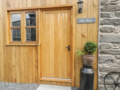 a wooden door of a building with a potted plant at The Barn in Corwen