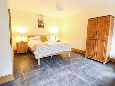 a bedroom with a bed and a tiled floor at Hay Store in Corwen