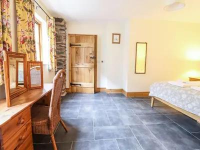 a bedroom with a desk and a bed and a window at Hay Store in Corwen
