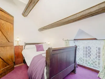 a bedroom with a bed and a window at The Druids in Corwen