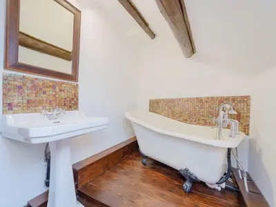 a bath tub and a sink in a bathroom at The Druids in Corwen