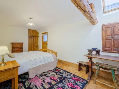 a bedroom with a bed and a desk and a table at The Druids in Corwen