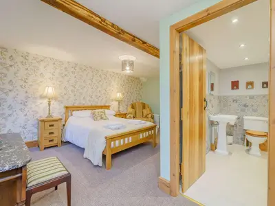 a bedroom with a bed and a bathroom at The Druids in Corwen