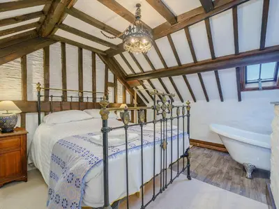 a bedroom with a bed and a bath tub at The Druids in Corwen