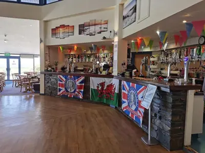 a bar with a counter with flags on it at Hiking in Snowdonia? Sea, beach and mountains view in Llwyngwril