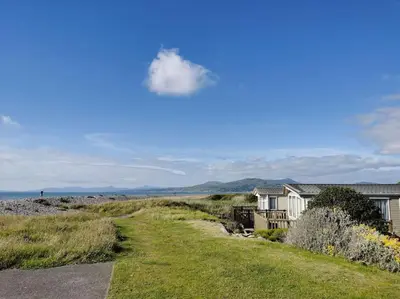 a house and a road next to a house at Hiking in Snowdonia? Sea, beach and mountains view in Llwyngwril