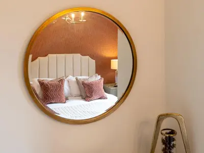 a mirror on a wall with a bed with pillows at Contemporary 2 bedroom home - Pass the Keys in Ludlow