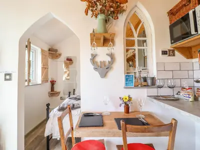 a kitchen with a table and chairs and a counter at Chateau Petit in Caersws