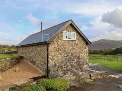 a stone building with a window on it at Bryn Eglwys Cottage in Tywyn