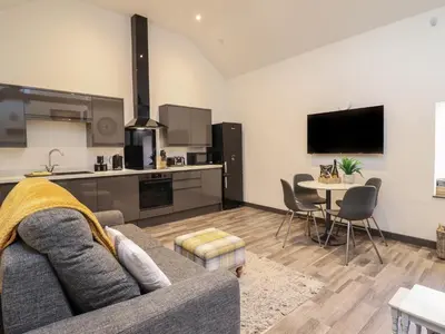 a living room with a couch and a table at Bryn Eglwys Barn in Tywyn