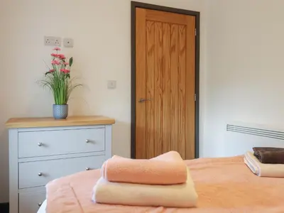 a bedroom with a bed with two towels on it at Bryn Eglwys Barn in Tywyn
