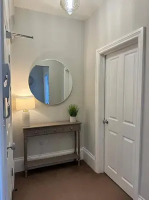 a bathroom with a mirror and a table with a lamp at Swn Y Mor 4 Aberystwyth in Aberystwyth
