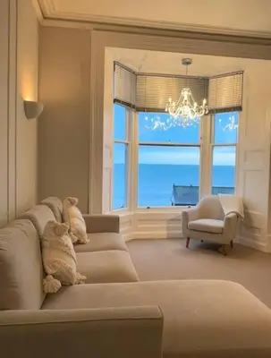 a living room with a couch and a large window at Swn Y Mor 4 Aberystwyth in Aberystwyth