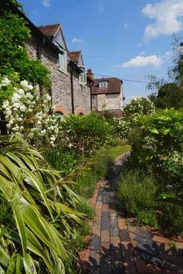 a stone path in front of a house at Nest Holiday Hideaway Wren Cottage-Beautiful Location in the Long Mynd Area of Outstanding Natural Beauty- WHIRLPOOL JACUZZI BATH! in Picklescott