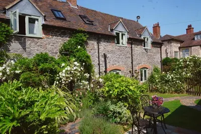 a garden in front of a stone house at Nest Holiday Hideaway Wren Cottage-Beautiful Location in the Long Mynd Area of Outstanding Natural Beauty- WHIRLPOOL JACUZZI BATH! in Picklescott