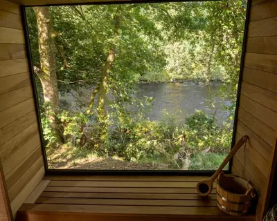 a window in a cabin with a view of a river at The Boatshed at Camp Plas in Welshpool