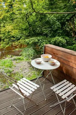 a table and two chairs on a wooden deck at The Boatshed at Camp Plas in Welshpool