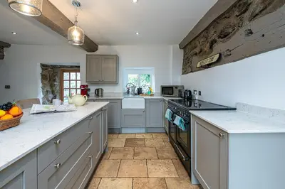 a kitchen with white cabinets and a counter top at Ty Mawr Llanfair in Llanfair