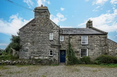 an old stone house with a blue door at Ty Mawr Llanfair in Llanfair