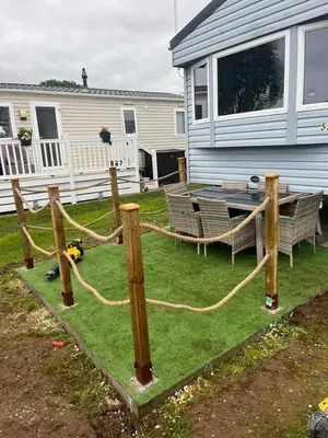 a yard with a rope and a table and a house at Caravan 521 shuker Barmouth in Talybont