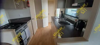 a kitchen with yellow writing on the counter top at Caravan 521 shuker Barmouth in Talybont