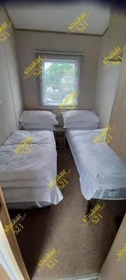 a small room with three beds and a window at Caravan 521 shuker Barmouth in Talybont