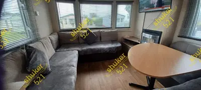 a living room with a couch and a table at Caravan 521 shuker Barmouth in Talybont