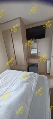 a bedroom with a bed with yellow writing on it at Caravan 521 shuker Barmouth in Talybont