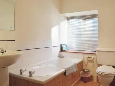 a bathroom with a tub and a toilet and a sink at Granary Cottage in Oswestry