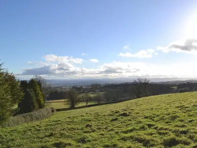 a grassy hill with a view of a field at Granary Cottage in Oswestry