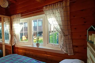 a bedroom with two windows and a bed in it at 299 Willow Lodge in Trawsfynydd