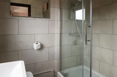 a bathroom with a shower and a toilet and a sink at Lake House in Brecon