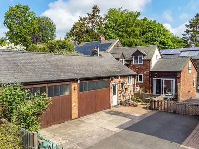 a house with a garage and a brick building at The Coach House- Uk45660 in Bishops Castle